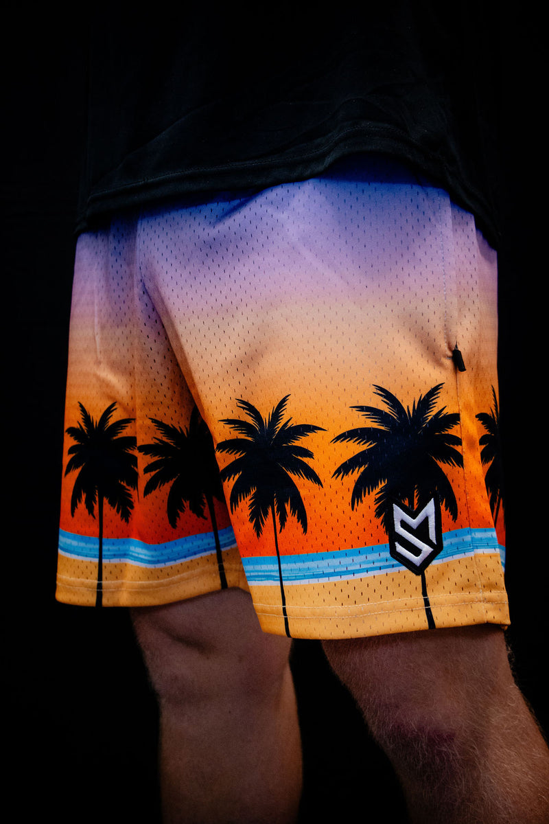 Shorts with palm tree design and gradient colors on a dark background